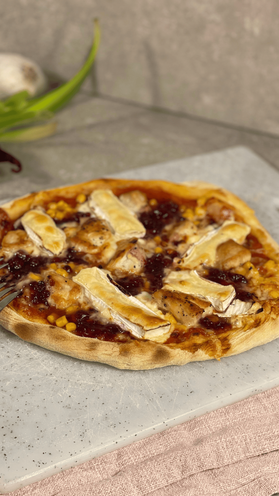 Das Bild zeigt einen Pizza mit Camembert und Preiselbeeren.
