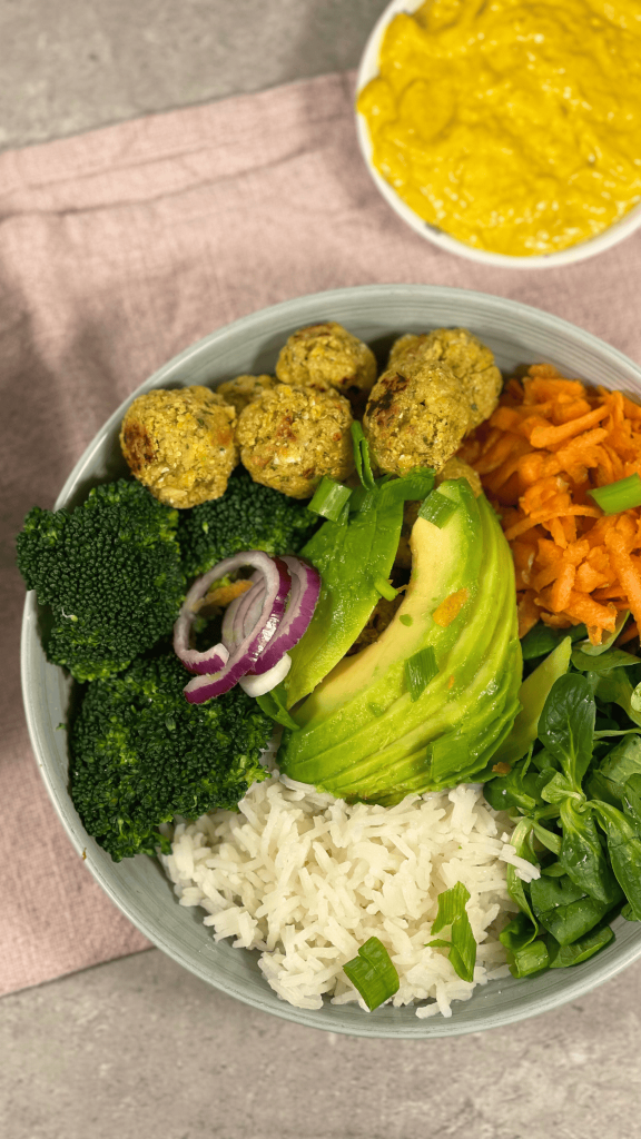 Leckere Falafel Bowl mit Gemüse und Avocadoscheiben.
