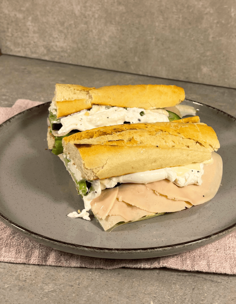 Ein angeröstetes Baguette, belegt mit Burrata, dessen cremige Textur langsam am Rand hinunterläuft