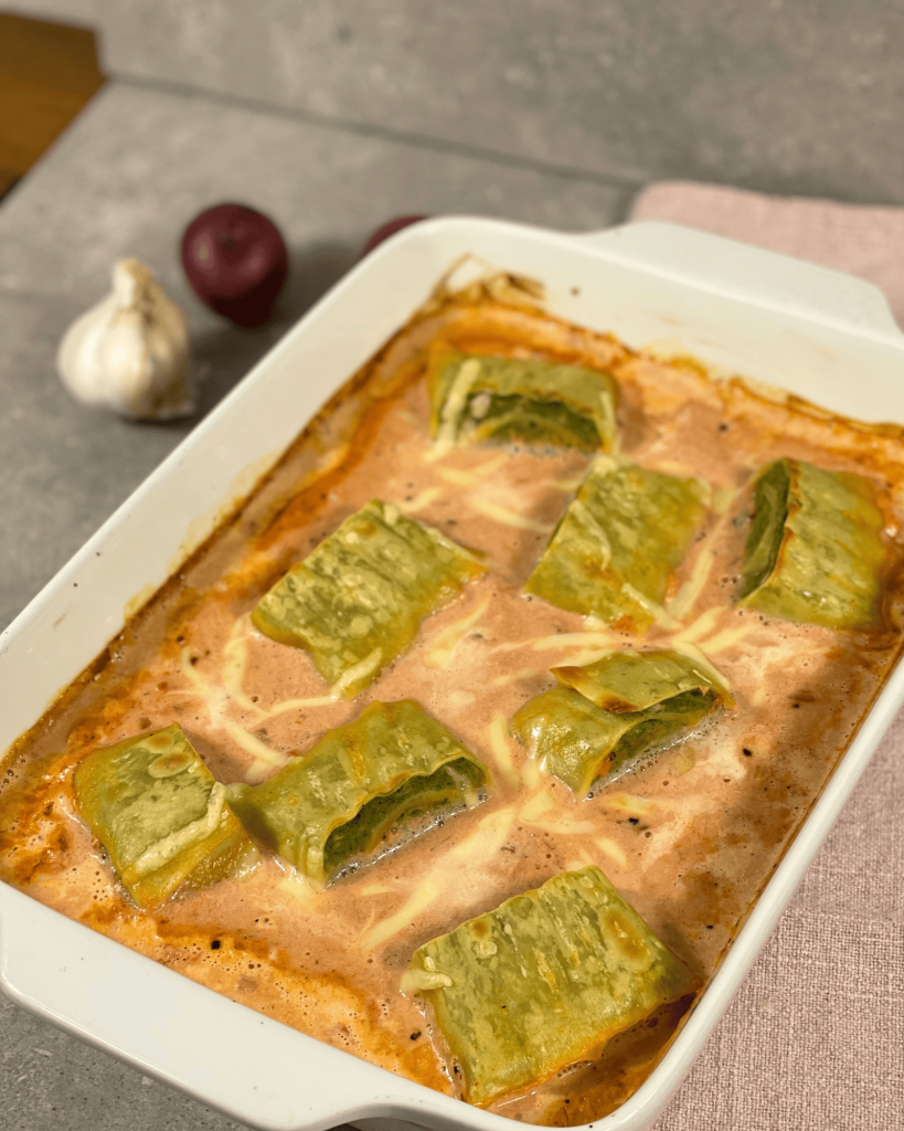Das Bild zeigt einen Maultaschen Auflauf in einer cremigen Tomaten-Sahnesoße mit überbacken Mozzarella. 