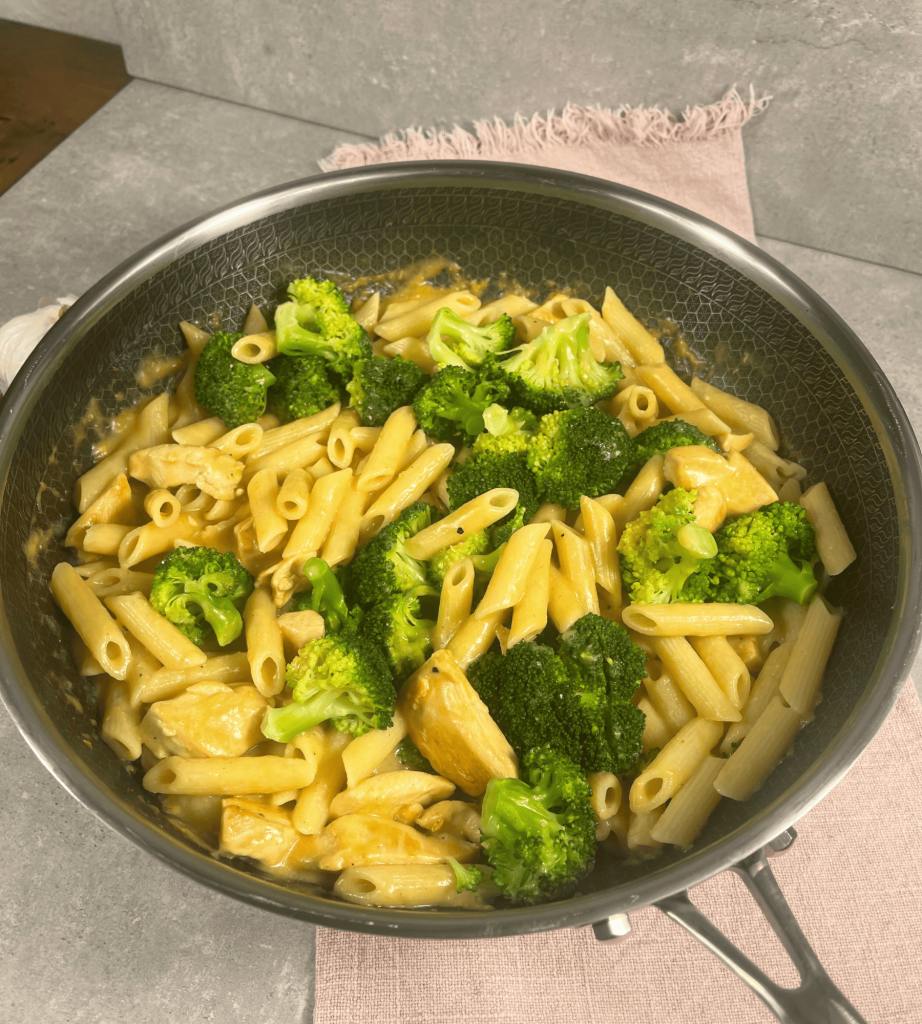 Das Bild zeigt eine cremige Hähnchen-Brokkoli-Pasta in einer Pfanne. 