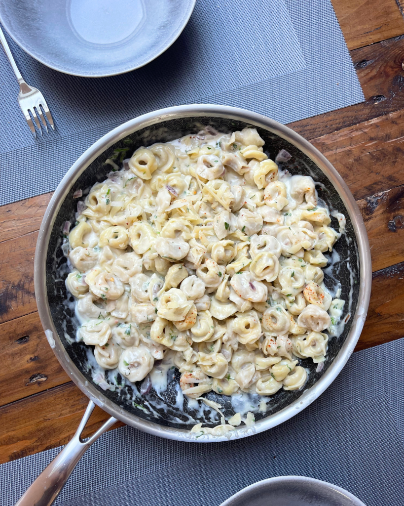 Eine Pfanne mit selbstgemachten Tortellini in Parmesan Soße.